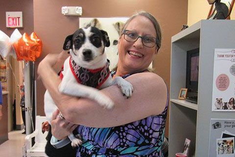 smiling lady while holding a dog