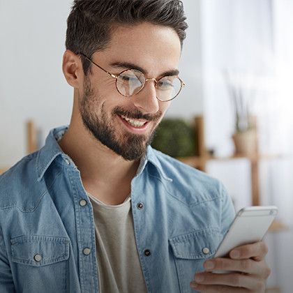 Man with glasses looking at his mobile phone