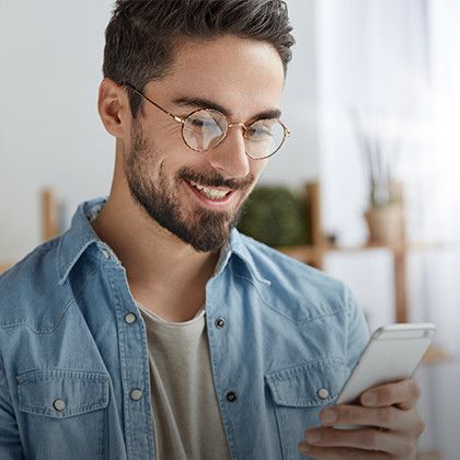 Man with glasses looking at his mobile phone