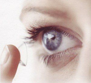 Woman putting contact lens in eye