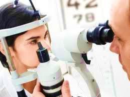 optometrist checking eye of patient