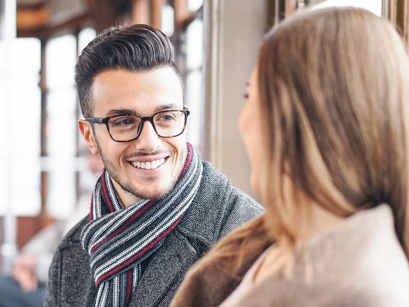 Man with glasses talking to a woman