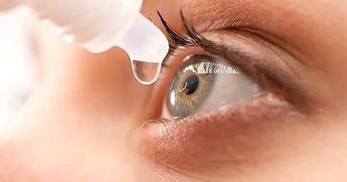 woman placing eye drops in her eyes