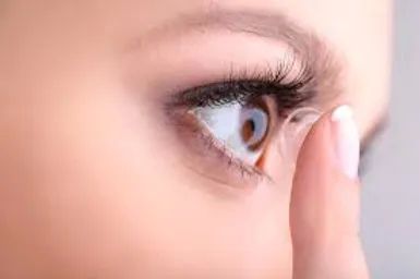 woman placing contact lenses in her eye