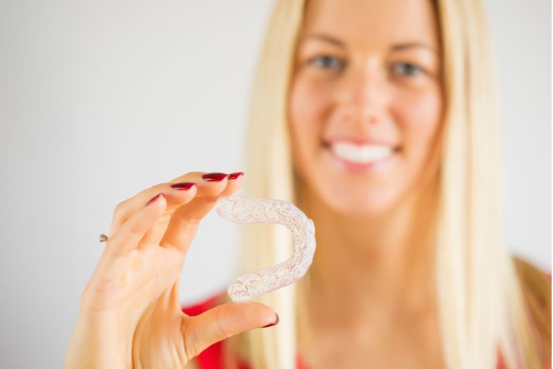 Blonde Lady Holding Invisalign