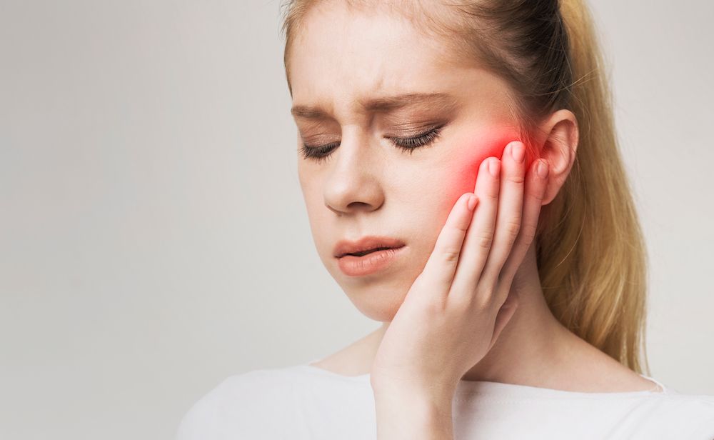 young blonde woman in mouth pain