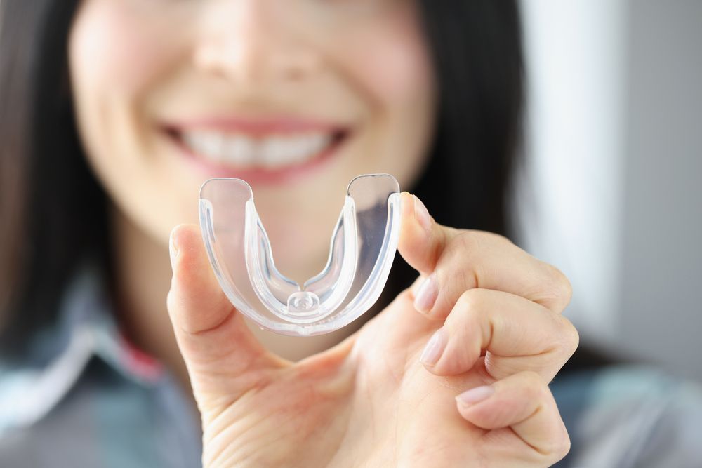 Woman holding a mouth guard, sleep apnea