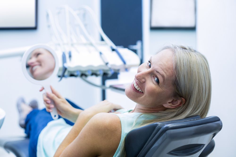 dental patient holding a mirror