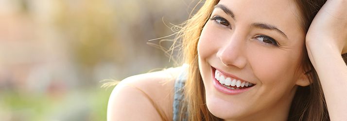 Woman smiling with perfect smile in a park and looking at camera