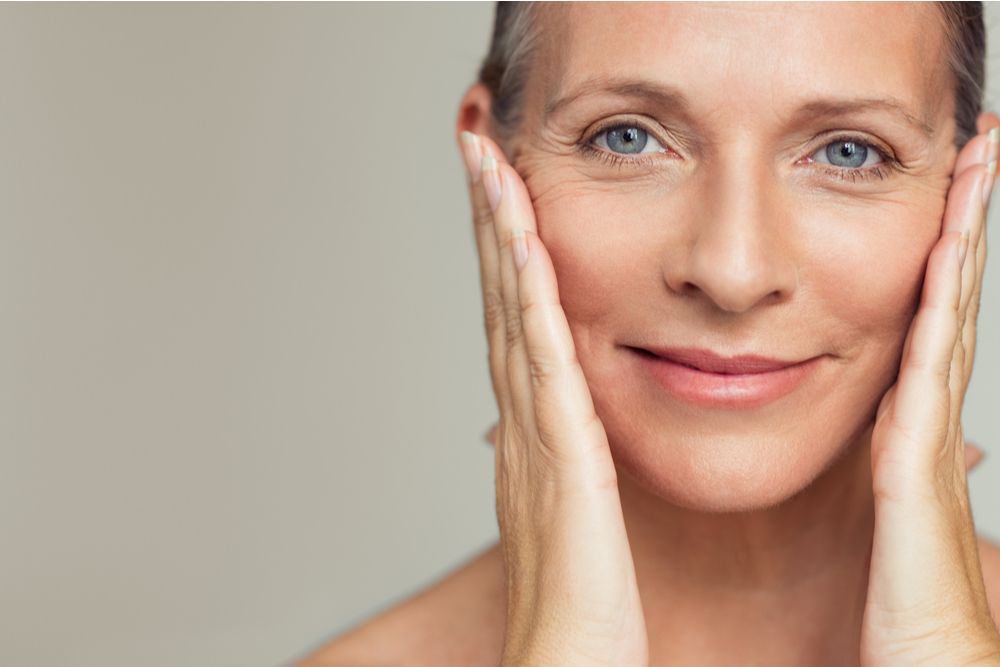 Beautiful senior woman touching her perfect skin