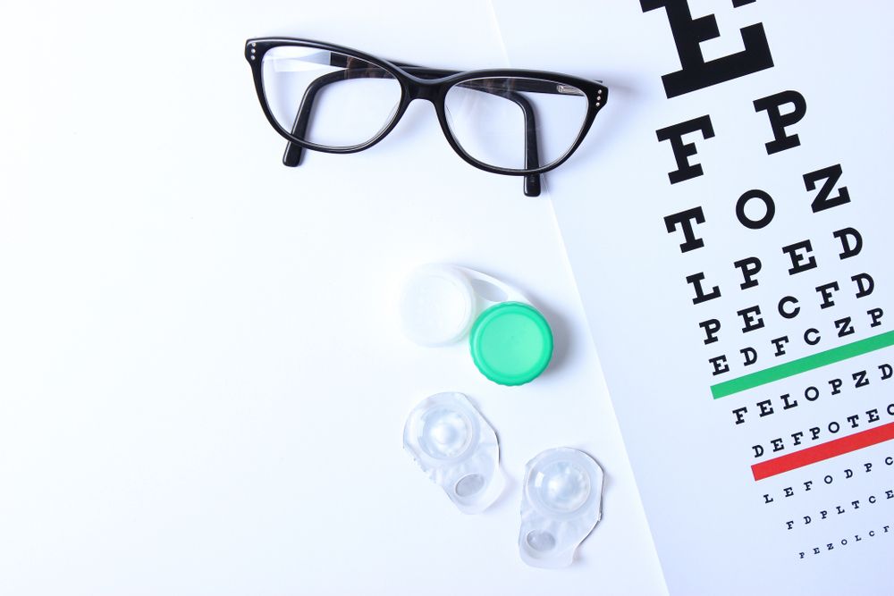 glasses and lenses for vision correction and a table for checking vision on a light background.