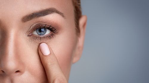 woman with her finger near her eye