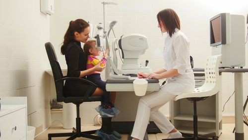 Mother and daughter with opthalmologist