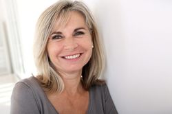 Smiling middle-aged woman in gray shirt