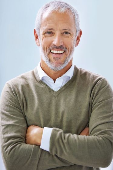Headshot of a man laughing, displaying even, white teeth.