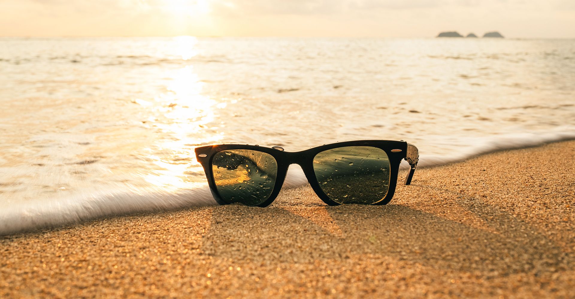Sunglasses from eye doctor near me on a beach at sunset in Jupiter, FL